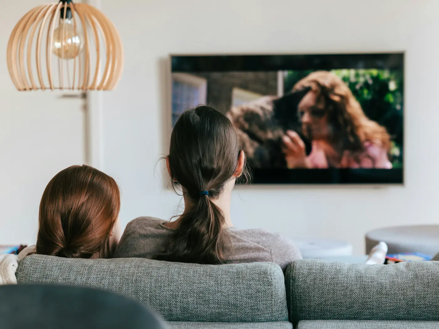 A couple relaxing on the sofa while watching TV in a bright living room